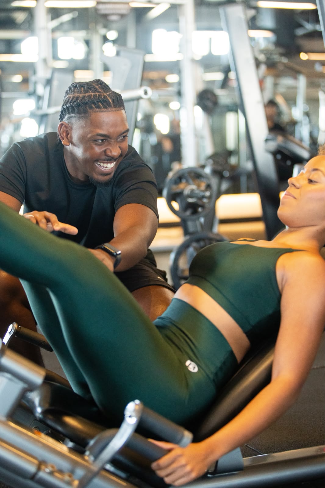 Pedro Henrique acompanhando uma aluna no leg press